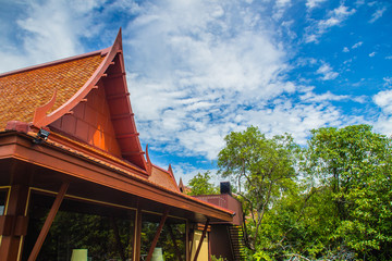 Gable roof house design in Thai style with blue sky background. Wooden roof house of Thai style with blue sky.