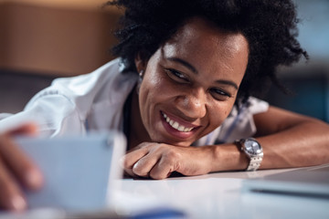 Wall Mural - Happy black healthcare worker taking selfie with smart phone.