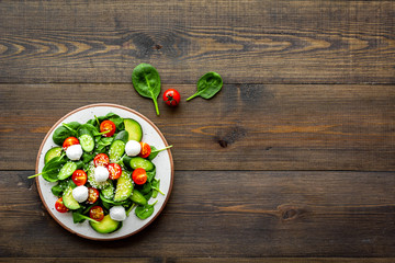 Vegetarian meal. Fresh vegetable salad on dark wooden background top view space for text