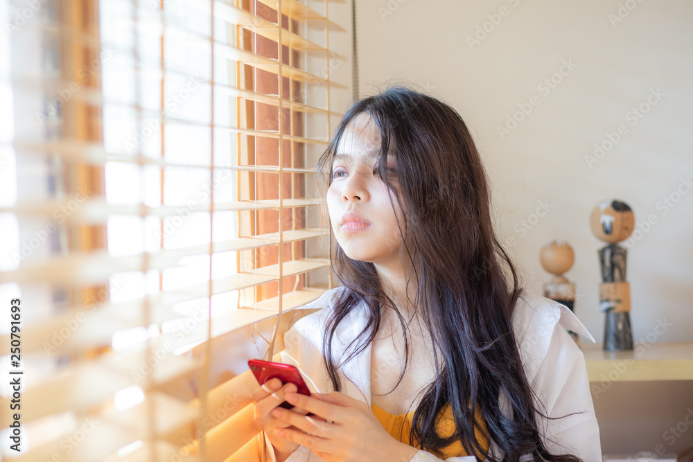 Sexy young asian beautiful women using smartphone near window with sun ...