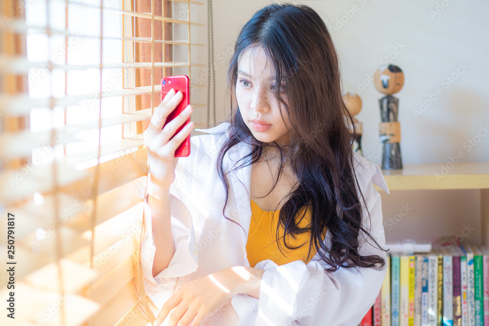 Sexy young asian beautiful women using smartphone near window with sun ...