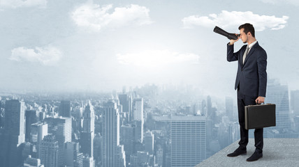 Wall Mural - businessman looking forward to a city with binoculars from skyscraper concept