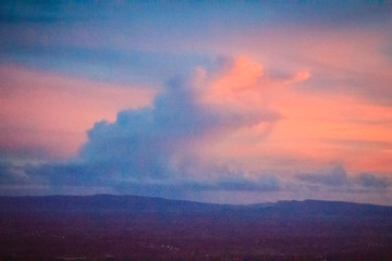 Wall Mural - Dusk sky and cloud at morning dawn background. Vibrant colors of the sky with clouds from dusk till dawn. Dramatic evening cloudscape in the city. Twilight sky began to change from blue to orange.