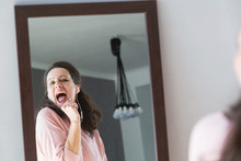 Woman Listening To Music And Singing In Front Of Mirror