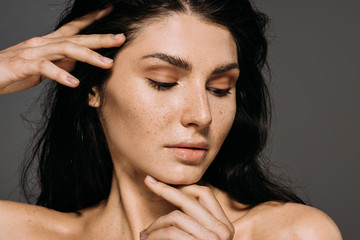 tender brunette girl with freckles on face isolated on grey