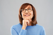 Vision And Old People Concept - Portrait Of Smiling Senior Woman In Glasses Looking Up And Dreaming Over Grey Background