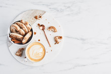 Coffee Or Cappuccino With Latte Art And Gingerbread Biscuits On White Marble Serving Plate Over Marble Background. Breakfast Concept. Top View With Copy Space For Text.