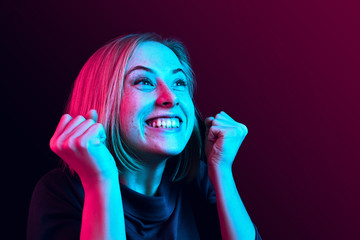 I won. Winning success happy woman celebrating being a winner. Dynamic image of caucasian female model on neon studio background. Victory, delight concept. Human facial emotions concept. Trendy colors