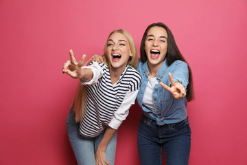 Poster - Young women laughing together against color background