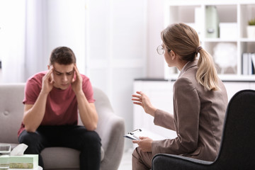 Poster - Psychotherapist working with young man in office