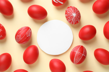 Wall Mural - Flat lay composition of painted red Easter eggs and card on color background, space for text