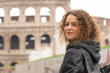 © gallofilm - Happy young female tourist in front of the Colosseum, or Coliseum in Rome, Italy