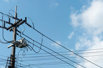 Electrical pole with many cable under blue sky. at Thailand.