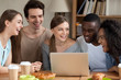© fizkes - Smiling multiracial people using laptop together, having fun