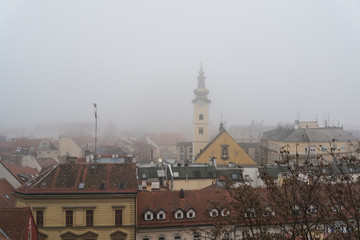 View of the Upper town with St Mary's Church Baroque tower in fog, Zagreb, Croatia