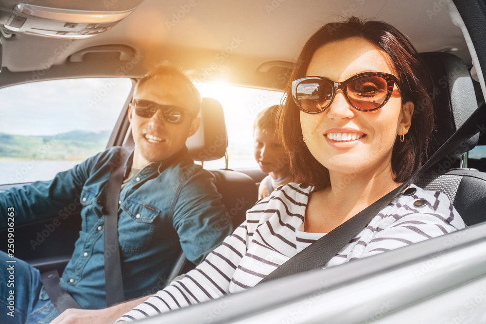 Cheerful young traditional family has a long auto journey and smiling ...