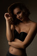 © vpavlyuk - Dramatic portrait of awesome brunette model with wavy hair wears bra, posing in the shadows