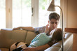 © Cavan Images - Young couple about to kiss on sofa