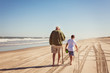 © Cavan Images - Grandfather and grandson (8-9) on beach by sea