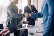 © alfa27 - Business people in formal wear shaking hands, finishing up a meeting, establishing multi-ethnic partnership, making deal in a meeting.