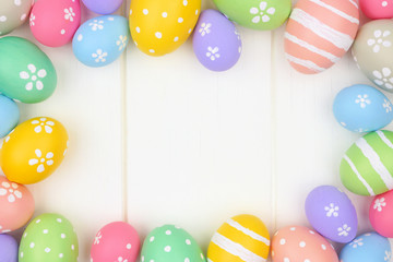 Colorful pastel Easter Egg frame against a white wood background. Top view with copy space.