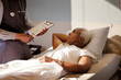 © Cavan Images - Senior man in hospital bed looking at nurse