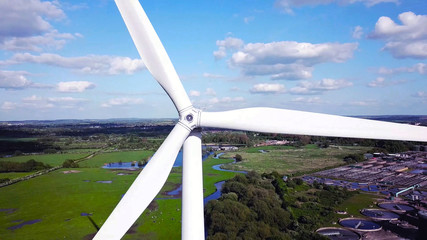 Wall Mural - Close up aerial view of Wind turbine with rural area in the background.