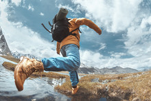 Man Hiker Jumps Across Water In Mountain Area