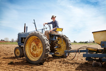 Young Man Sitting On Tractor In Field 