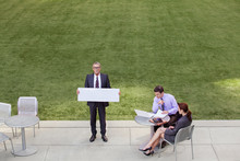 Businessman Holding Sign During Meeting In Park 