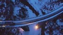 Landwasser Viaduct With Railway And Train At Winter Evening. Mountain Gorge. Aerial View. Swiss Alps. Drone Flies Forward, Camera Tilts Down