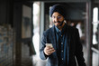 © LUMINA IMAGES - Handsome Indian sikh businessman wearing turban walking and typing on his cell phone.