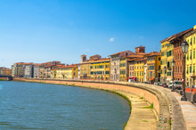 Row Of Old Colorful Buildings Houses On Embankment Promenade Of Arno River In Historical Centre Of Pisa Town With Blue Sky White Clouds Copy Space Background In Sunny Day, Tuscany, Italy
