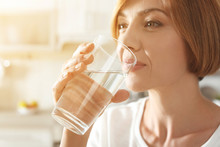 Woman Drinking Clean Water From Glass In Kitchen, Closeup