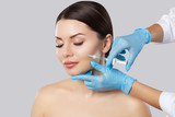 Fototapeta  - The doctor cosmetologist makes the Rejuvenating facial injections procedure for tightening and smoothing wrinkles on the face skin of a beautiful, young woman in a beauty salon.Cosmetology skin care.
