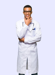 Wall Mural - Young afro american man doctor with glasses and smiling on isolated background