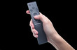 © splitov27 - Hand holds tv remote isolated on black background.