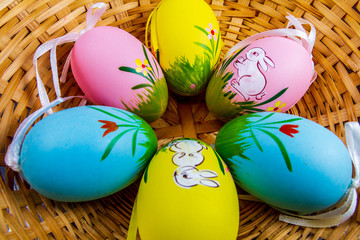 Wall Mural - Colorful ester eggs with drawings in a basket isolated