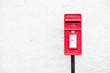 © Richard Johnson - Red post mail box against plain white wall background