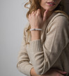 © Alsu - bracelet made of moonstoneis on the hand, on the arm is a bracelet made of white stones, girl on white background