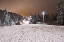 Kuusamo / Finland: View From The Illuminated Talvijarvi Slope To The Upper Lifts And Slopes In The Ruka Ski Area On A Mystic Evening In February