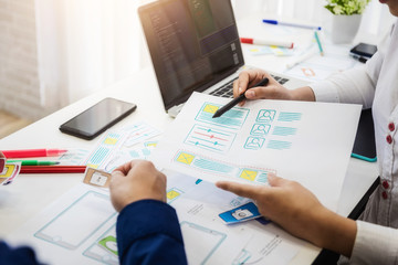 Programmer developing technologies about wireframe application designe of mobile phone. User experience Design concept.