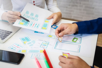 Two programmer working sketches for mobile phone application in office. User experience concept.