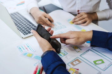 Two programmer test coding technologies with mobile phone for comparing mobile and desktop website. User experience concept.