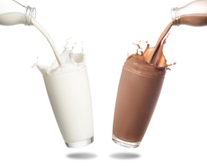 Pouring milk and chocolate milk from bottle into glass with splashing isolated on white background.