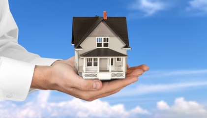 Poster - Male hands holding house model on background