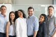 © fizkes - Happy team standing together in row looking at camera