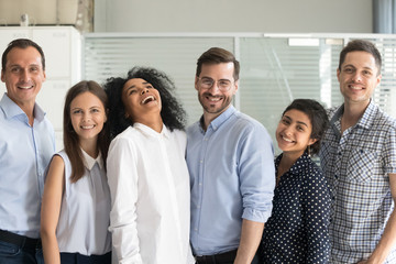 Canvas Print - Happy team standing together in row looking at camera 