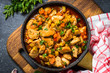 © nadianb - Chicken stew with vegetables black stone table, top view.