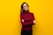 Woman with turtleneck over yellow wall with glasses and happy